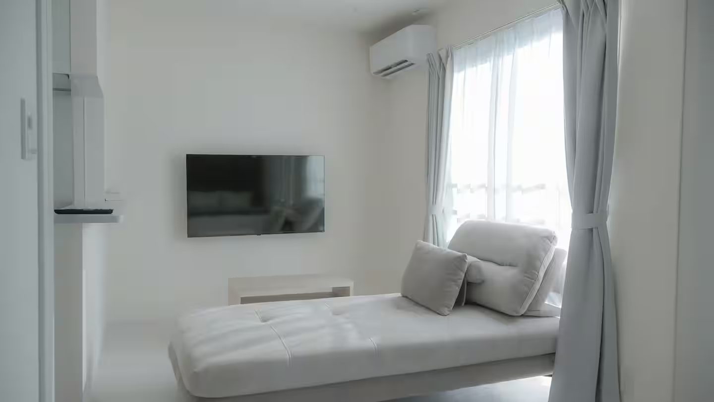 CHODO 益城の客室。ソファとテレビ、窓からの光